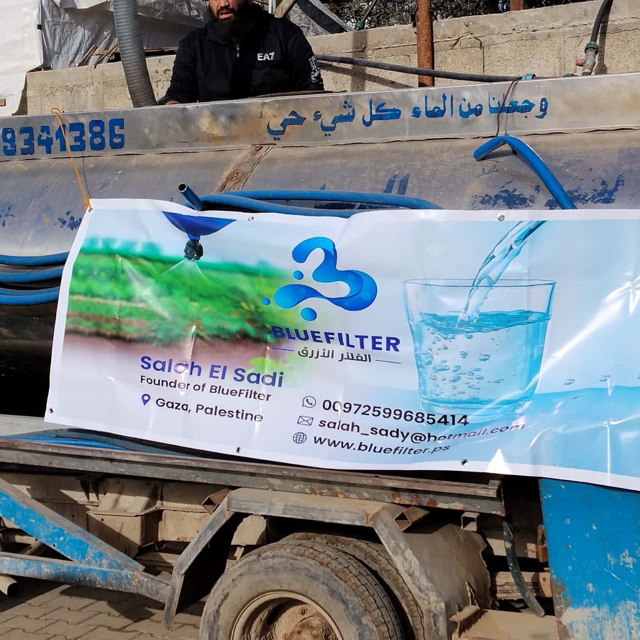 Blue Filter team member handing out clean water to displaced residents